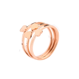 Three-piece stackable rose gold rings with heart charms and clover leaf design