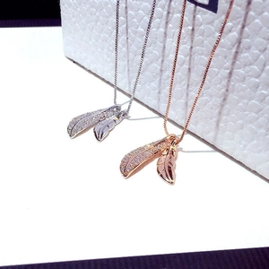 Elegant rose gold and silver double leaf necklaces with zircon accents on jewelry box