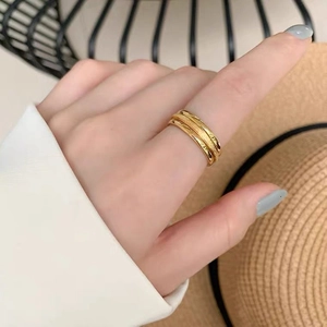 Three-layer stacked gold ring with polished finish worn on finger for a stylish daily look