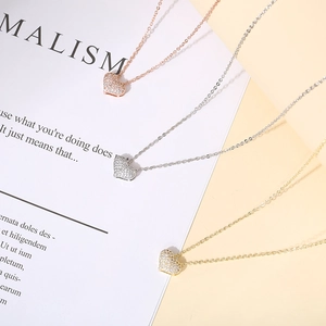Three heart-shaped pendant necklaces in gold, silver, and rose gold with pavé-set zircons