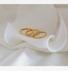 Macro detail of three-piece gold minimalist rings with polished and frosted matte texture