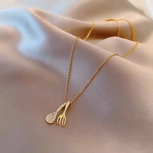 Creative gold cutlery necklace featuring a spoon with sparkling zircons and a fork pendant