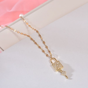 Detail of gold petal chain necklace with sparkling zircon-studded lock and key pendants