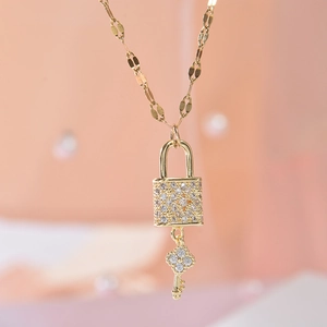 Golden titanium necklace featuring a sparkling zircon padlock and clover key pendant