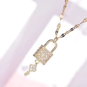 Detail shot of a sparkling gold clover key necklace with full diamond pave pendant