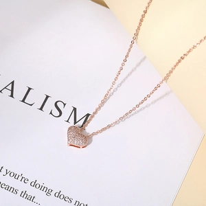 Macro shot of 14K rose gold heart pendant with pavé set cubic zirconia on stylish chain