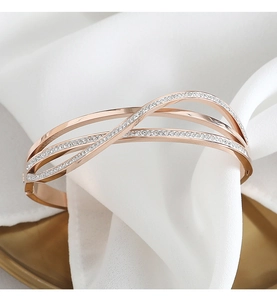 Dettaglio del bracciale multistrato in oro rosa con zirconi su seta bianca