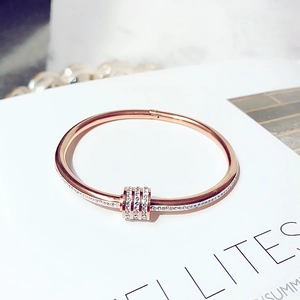 Dettaglio del bracciale rigido oro rosa con anelli in zircone bianco incastonati a mano
