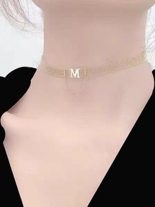 Detailed view of a gold woven mesh choker featuring a hanging M letter pendant