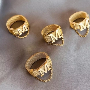 Detail of gold woven mesh ring with M initial pendant and MOM engraving on the side