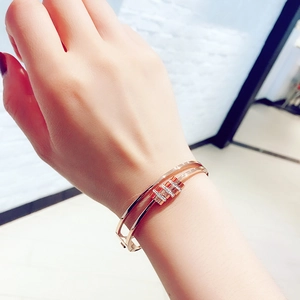 Vista dettagliata del bracciale a doppio giro in oro rosa con cilindri di zirconi