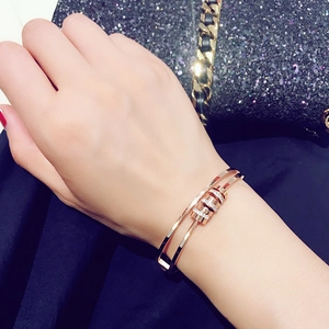 Dettaglio del bracciale in oro rosa a doppio strato con anelli in zircone al polso