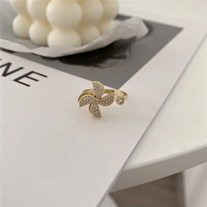 Detailed close-up of a gold windmill ring with sparkling white cubic zirconia stones