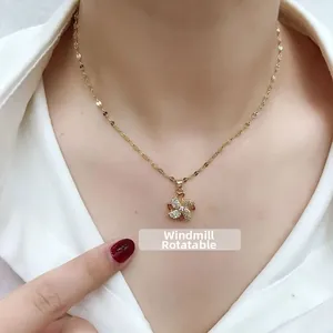 Detail showing the rotatable golden windmill pendant with sparkling zircons on a necklace