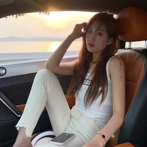Close-up of golden link necklace and bracelet set worn by a model in a car setting
