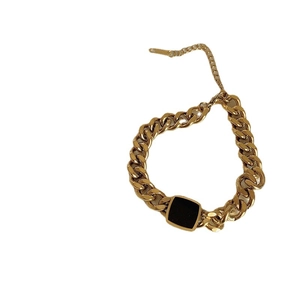 Chunky gold titanium curb chain bracelet featuring a bold black square charm and clasp