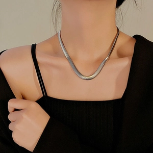 Detailed view of wide silver snake bone chain necklace in polished stainless steel