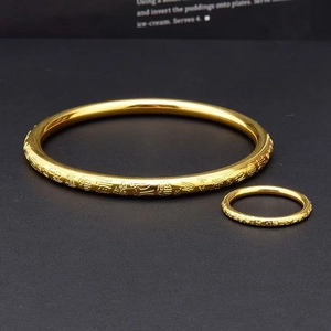 Close-up of golden stainless steel bracelet and ring set with engraved Fu character