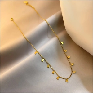 Elegante collar de mariposa en oro de 18 quilates con pequeños dijes en una cadena fina