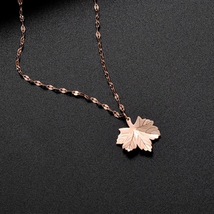 Detailed view of rose gold maple leaf pendant with textured veins and shiny faceted chain