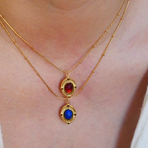 Zweilagige Goldperlenketten mit roten Achat- und Lapislazuli-Anhängern am Hals