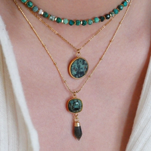Close-up of bohemian layered necklace with turquoise beads and square stone pendants