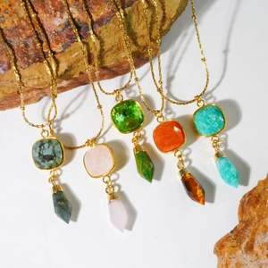 Detailed macro view of five colorful gemstone necklaces with gold bullet-shaped pendants