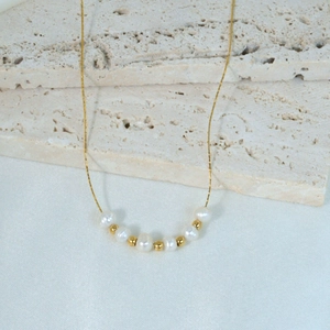 Elegante roestvrijstalen ketting met afwisselend witte parels en gouden metalen kralen