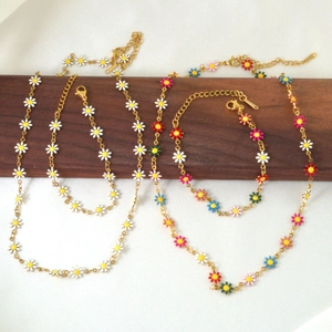 Detail of 18k gold plated titanium chain jewelry with colorful daisy enamel charms