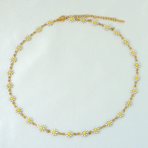 Close-up of titanium gold chain necklace featuring white and yellow enamel daisy charms