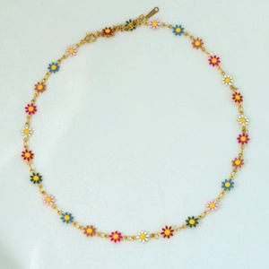 Detailed macro view of S-STEEL hallmark on golden 18k plated daisy chain necklace