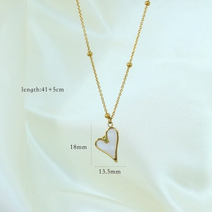 Dettaglio della collana con ciondolo a cuore dorato con inserto in madreperla e gemme