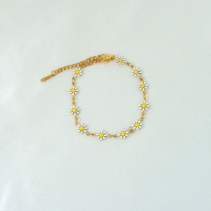 Detail of 18k gold daisy chain bracelet with white enamel flowers and lobster clasp