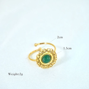 Detailed macro view of bohemian gold open ring with green natural stone and chain texture