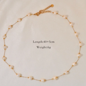 Detail view of pearl and amber bead necklace with lobster clasp on silk background