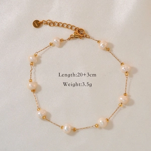 Macro detail of natural pearl bracelet in gold finish with lobster clasp on silk fabric
