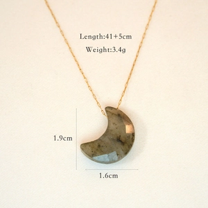 Close-up of golden moon pendant necklace with dimensions and technical specifications