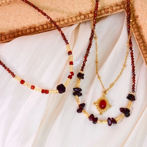Colliers vintage en agate rouge et perles d'or sur un élégant fond de soie blanche