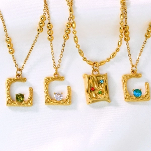 Detalle de los collares bañados en oro de 14k con colgantes en forma de C y circonitas