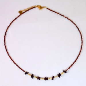 Vue détaillée du collier en perles de grenat avec accents dorés et pierres brutes
