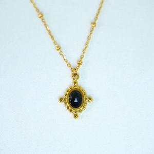 Detail of vintage 14k gold plated satellite chain with an oval black faceted gemstone pendant