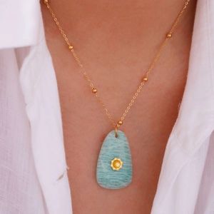 Minimalist 14K gold stainless steel necklace with blue stone teardrop pendant worn by model
