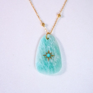 Detailed macro view of 14K gold-plated necklace with star-inlaid teardrop stone pendant