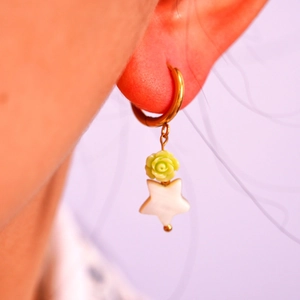 Detalle de pendientes de aro dorados hechos a mano con rosa verde claro y estrella blanca