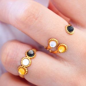 Detailed macro view of 14K gold stainless steel rings with white and black shell inlay