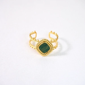 Detailansicht eines Retro-Goldrings mit quadratischem grünen Stein und Kordelstruktur
