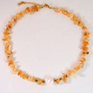 Detailansicht der 14K vergoldeten Kette mit orangefarbenen Natursteinen und Barockperle