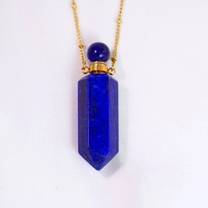 Macro detail of hexagonal lapis lazuli perfume bottle pendant with golden chain