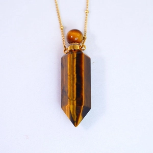 Macro detail of Tiger Eye hexagonal perfume bottle pendant with golden chain