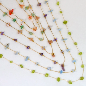 Detailed close-up of colorful natural gemstone beads on a gold stainless steel chain